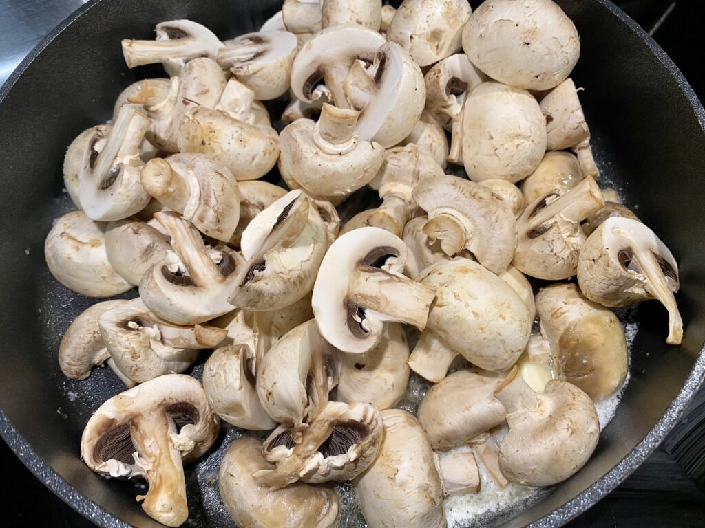 Add sliced mushrooms to skillet